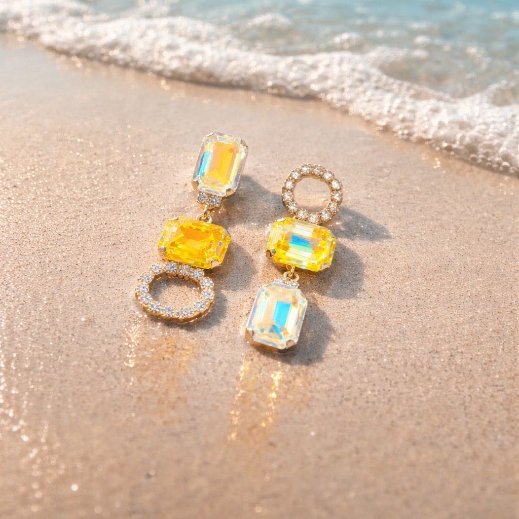 Luana Yellow Gold statement oorbellen met gele kristallen op het strand - DAMICE Jewelry unieke sieraden