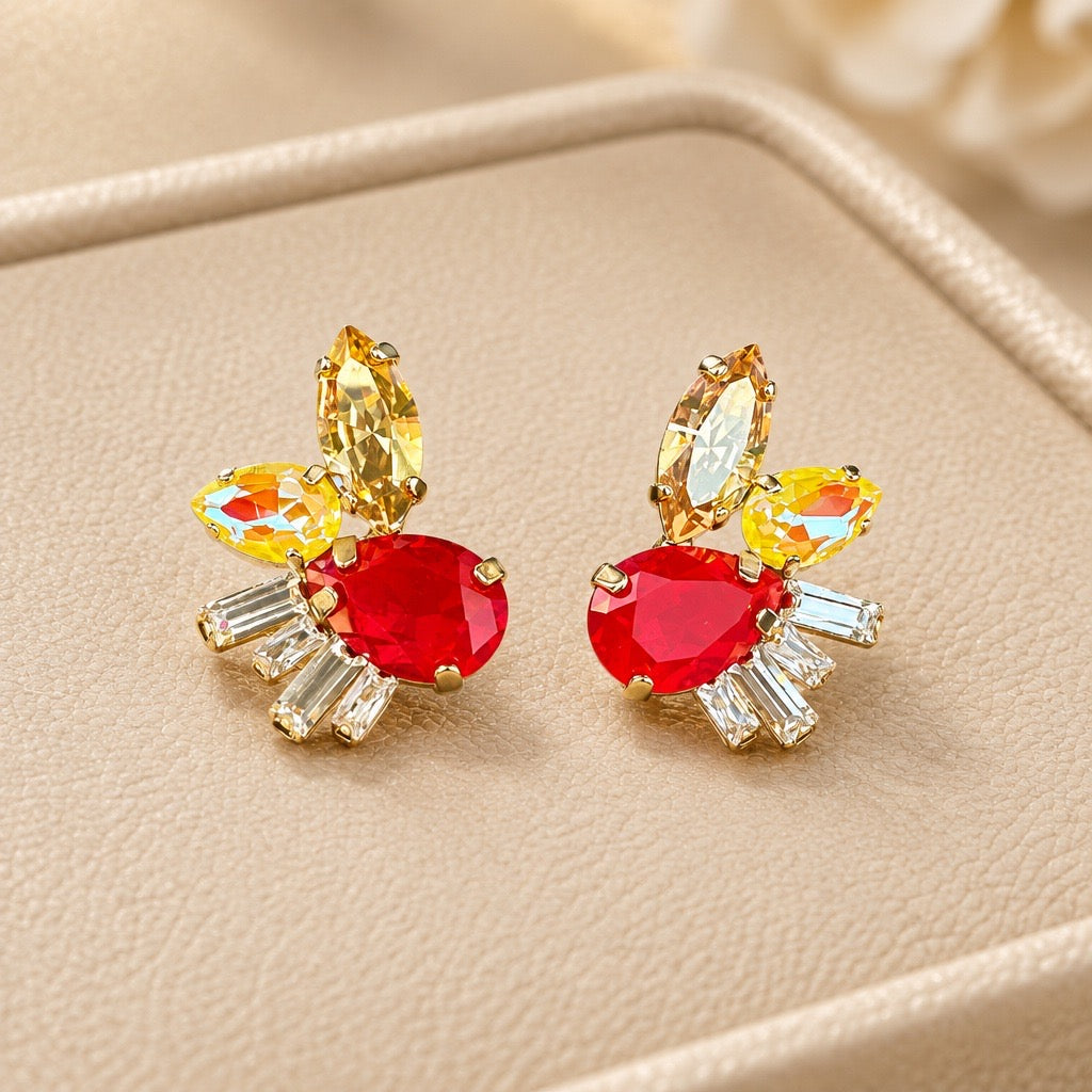 Zaria rode oorstekers met ovale rode steen, gele marquise en heldere baguette kristallen op beige sieradendoos, statement oorbellen van DAMICE Jewelry